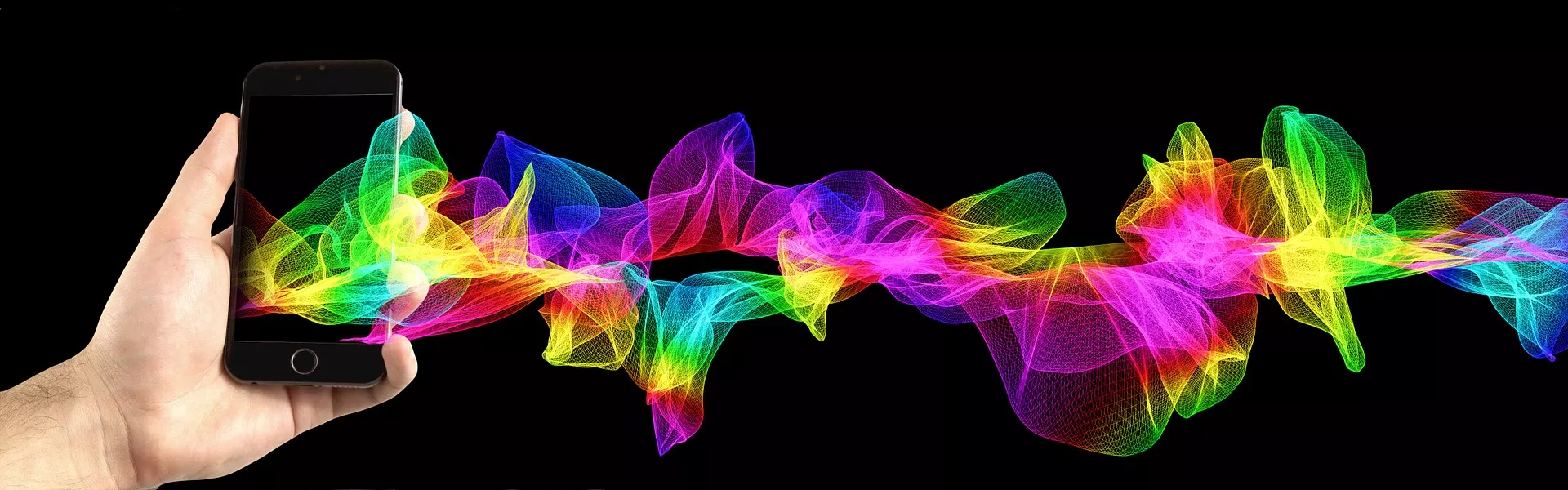In der Abbildung ist eine Hand sichtbar, welche ein Smartphone hält. Aus dem Smartphone kommen bunte Wellen heraus.