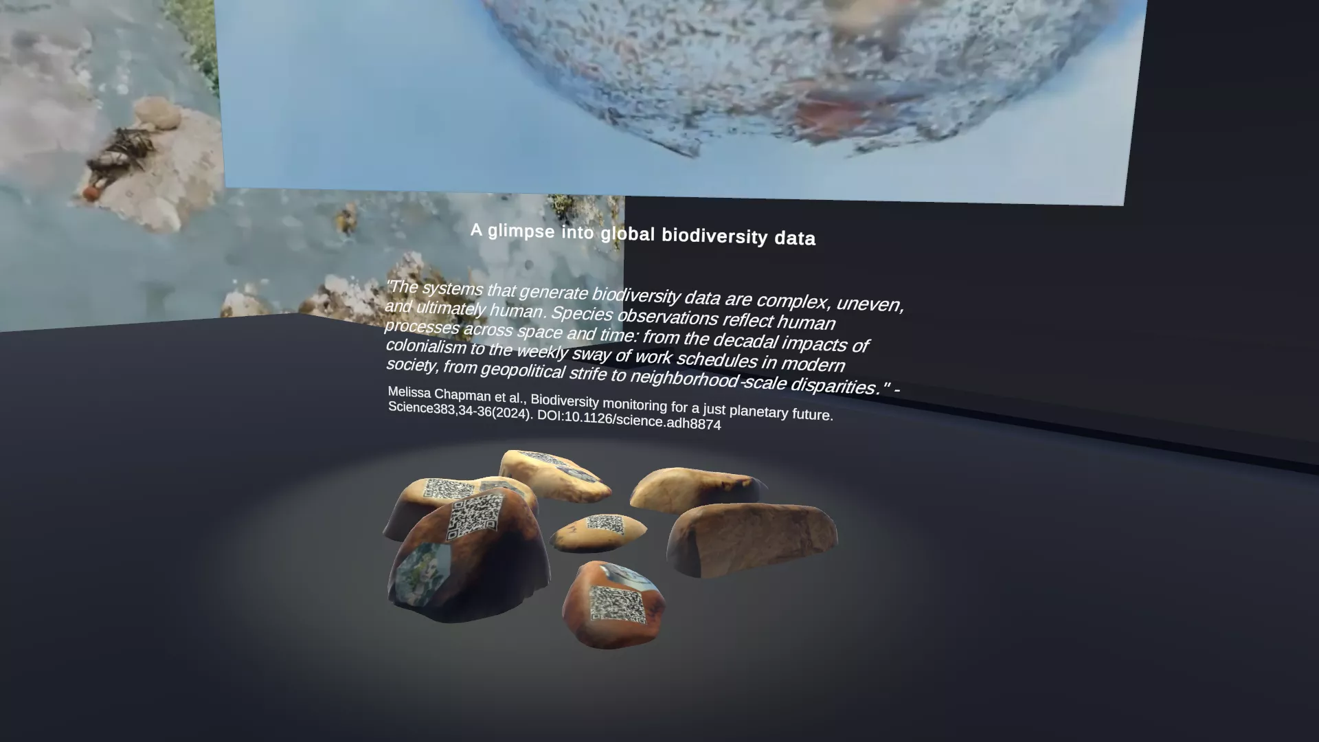 A digital exhibition display showcasing a theme on global biodiversity data. In the center, there is a floating image of a globe with a hazy, semi-transparent texture, appearing to represent biodiversity. Below the globe, a quote discusses the complexity and human influence on biodiversity data. The exhibition is set in a dark, immersive virtual space.