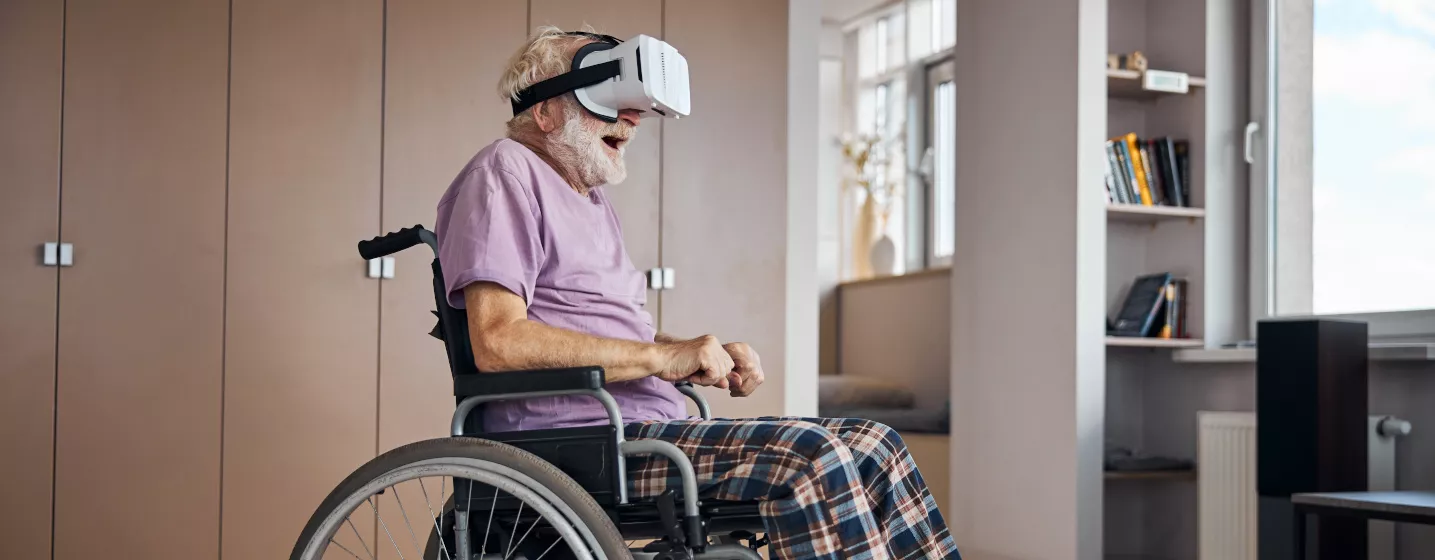 Alter Mann im Rollstuhl mit VR Brille