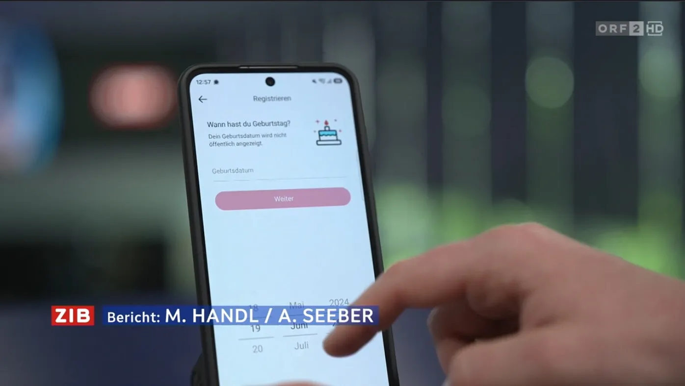 Hand tippt auf Smartphone-Bildschirm mit Registrierungsformular und Kalender zur Auswahl des Geburtstagsdatums. Unten links blendet ein Fernsehsender das Logo »ZIB« sowie die Textzeile »Bericht: M. HANDL / A. SEEBER« ein. Oben rechts befindet sich das Senderlogo »ORF 2 HD«.