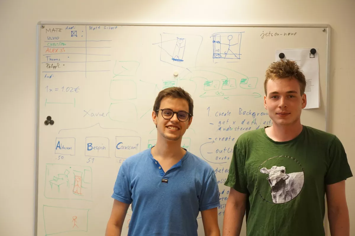 Silvio und Christian stehen vor einem Whiteboard