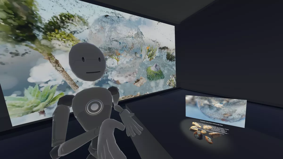 A virtual exhibition scene featuring a humanoid robot avatar in the foreground, standing in a dimly lit digital gallery space. Behind the avatar is a large, vibrant display of an abstract image that features a translucent globe filled with floating natural elements like plants and a human face partially covered in greenery. To the right of the scene, a smaller screen shows the same globe image. Below this screen is a glowing cluster of small, rock-like digital objects arranged on a platform.