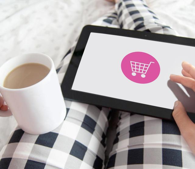 Bild einer Person, die im Pyjama mit Kaffeetasse in der Hand am Tablet online einkauft. Credit von Pixabay.