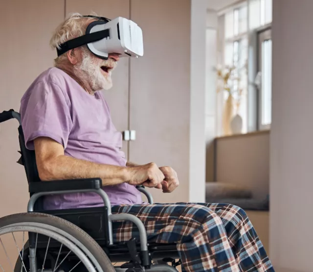 Alter Mann im Rollstuhl mit VR Brille