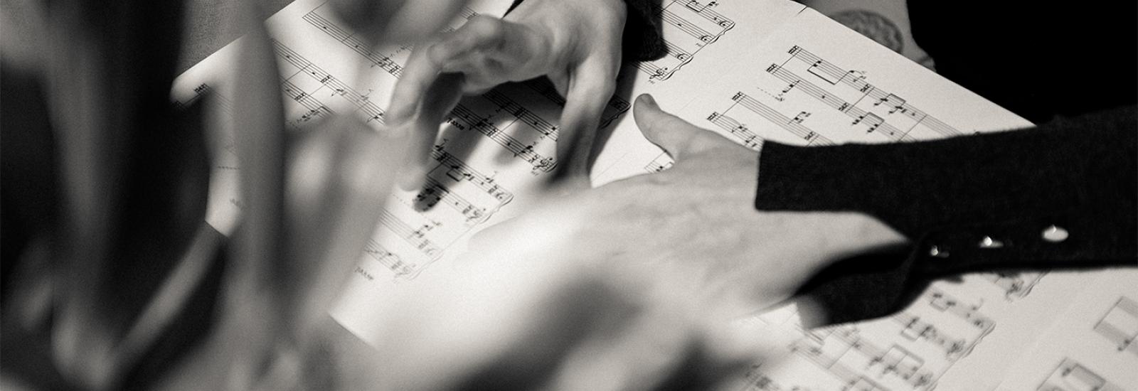 Open Sheet Music Display Background Image: Hands over Sheet Music