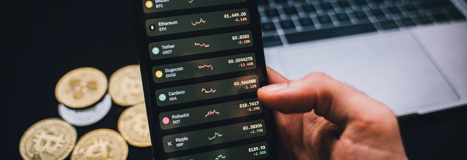 Smartphone in der Hand einer Person, Bildschirm zeigt Kryptowährungskurse. Foto von Alesia Kozik von Pexels