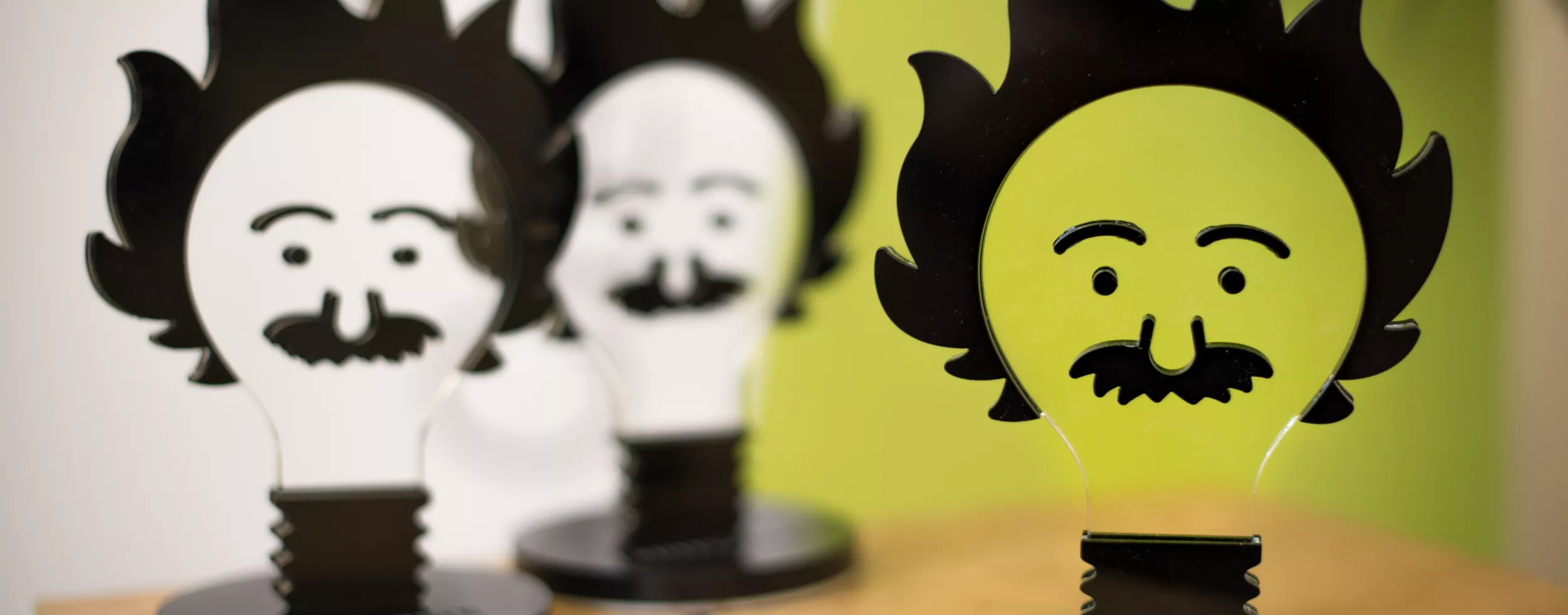 3 Awards nebeneinander in der form einer Glühbirne, die aussieht wie Albert Einstein
