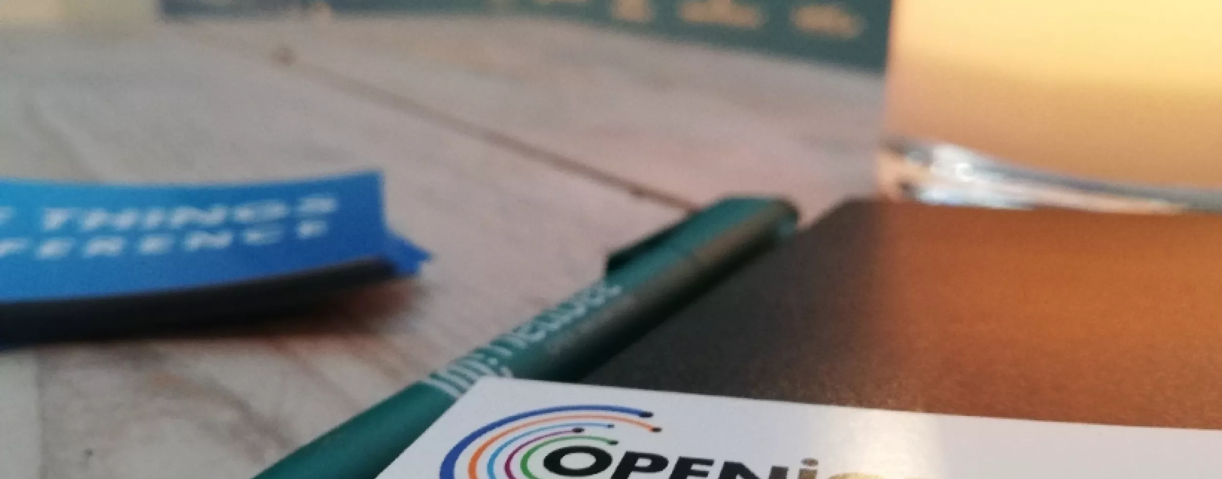 Bild von Visitenkarte OpenIoT, Netidee Kugelschreiber und The Things Conference Plakatwand.
