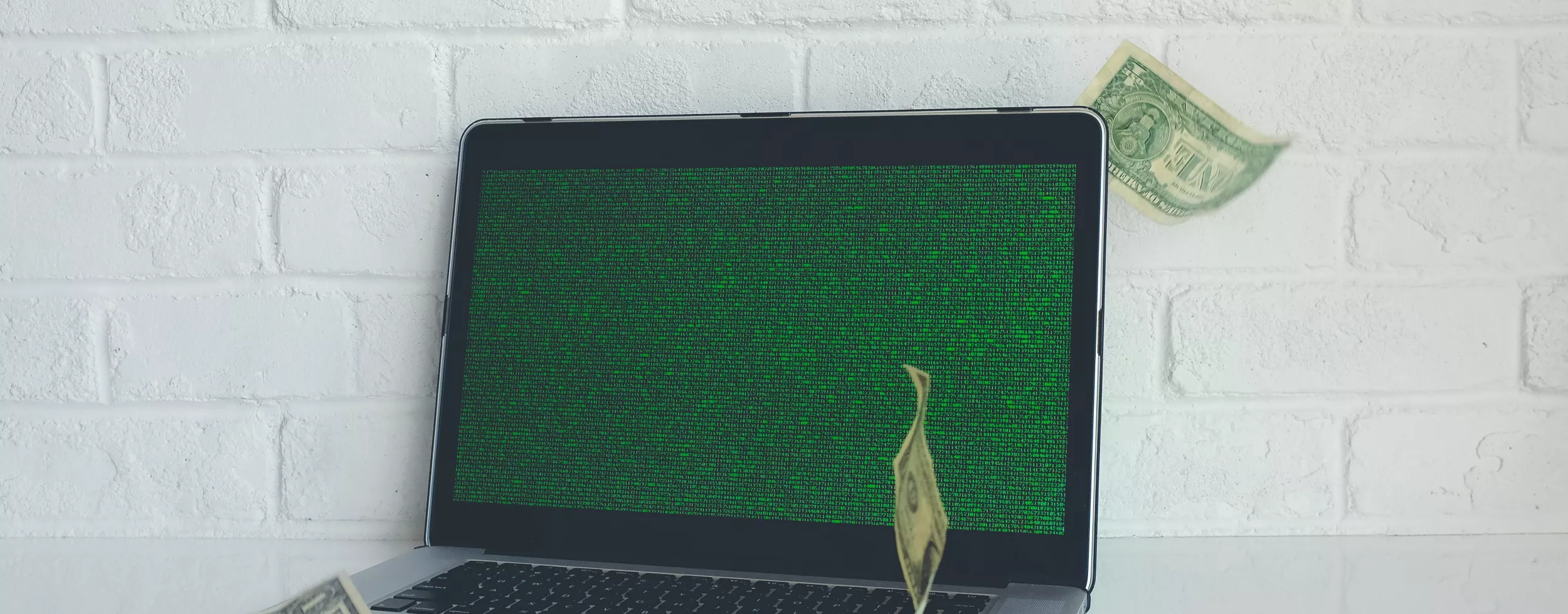 Ein Laptop mit Code und Geldscheinen