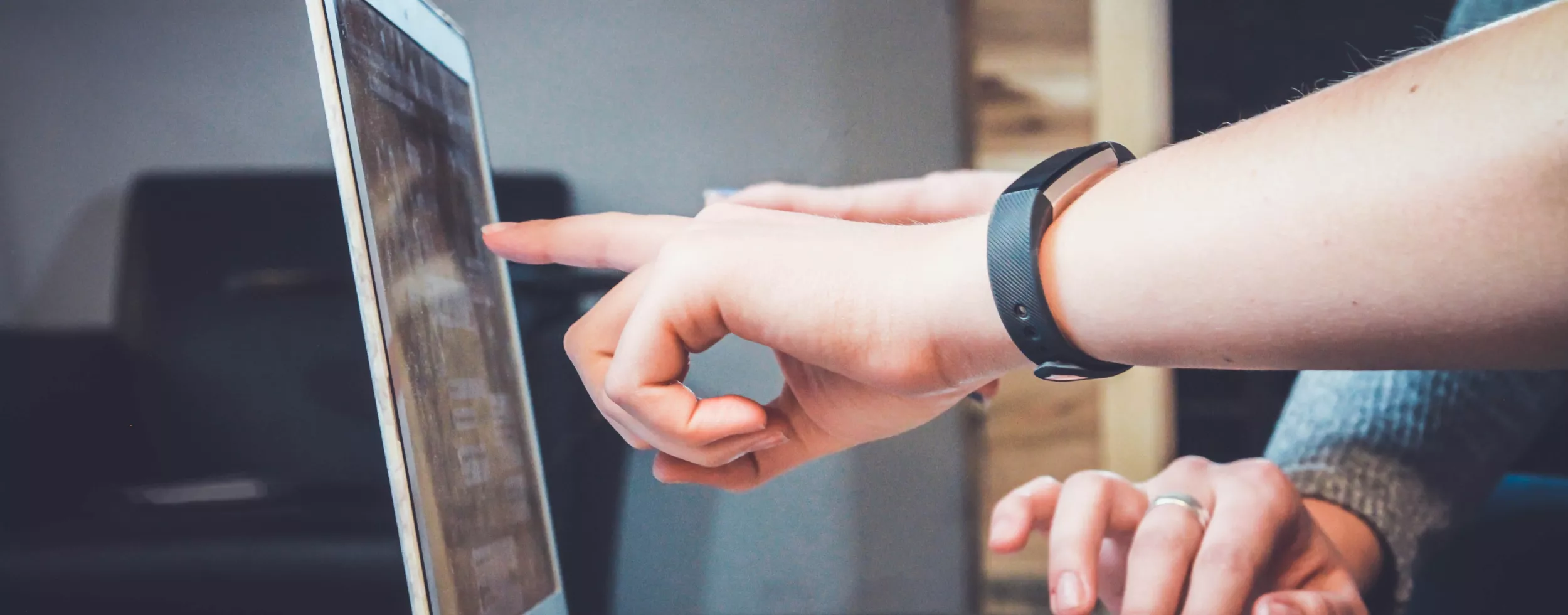 Eine Person deutet auf einen Laptop