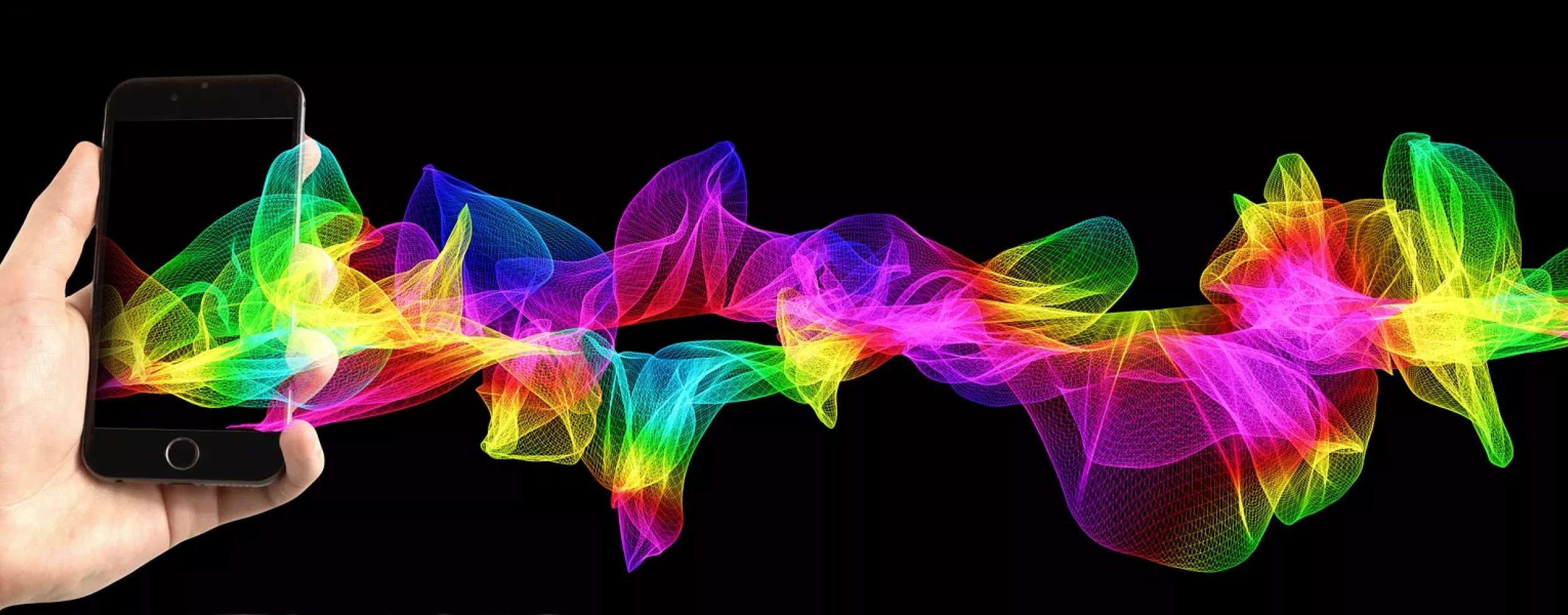 In der Abbildung ist eine Hand sichtbar, welche ein Smartphone hält. Aus dem Smartphone kommen bunte Wellen heraus.