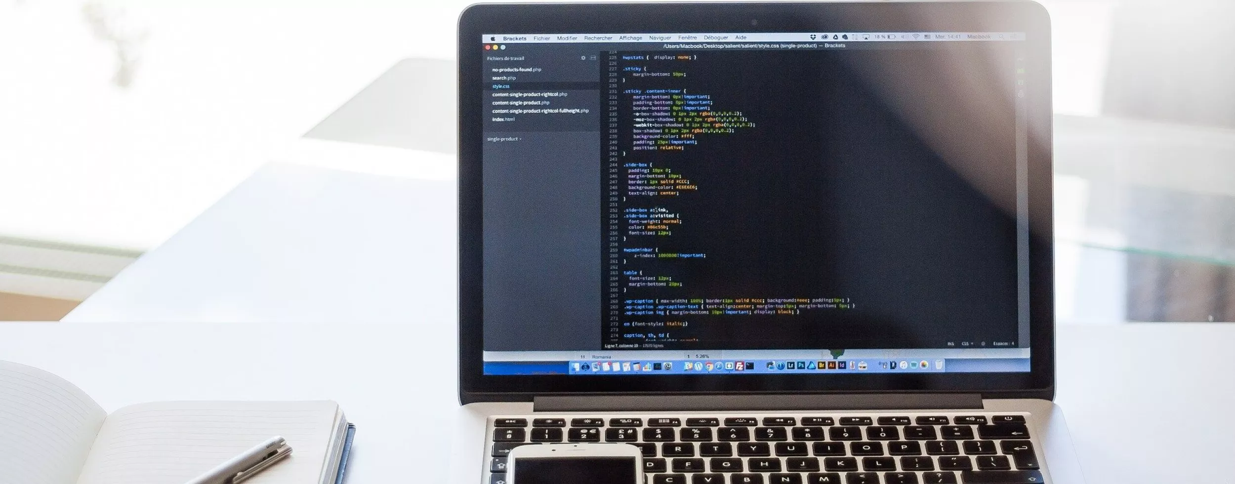 Auf dem Bild ist ein aufgeklappter Laptop sowie ein Smartphone zu sehen.