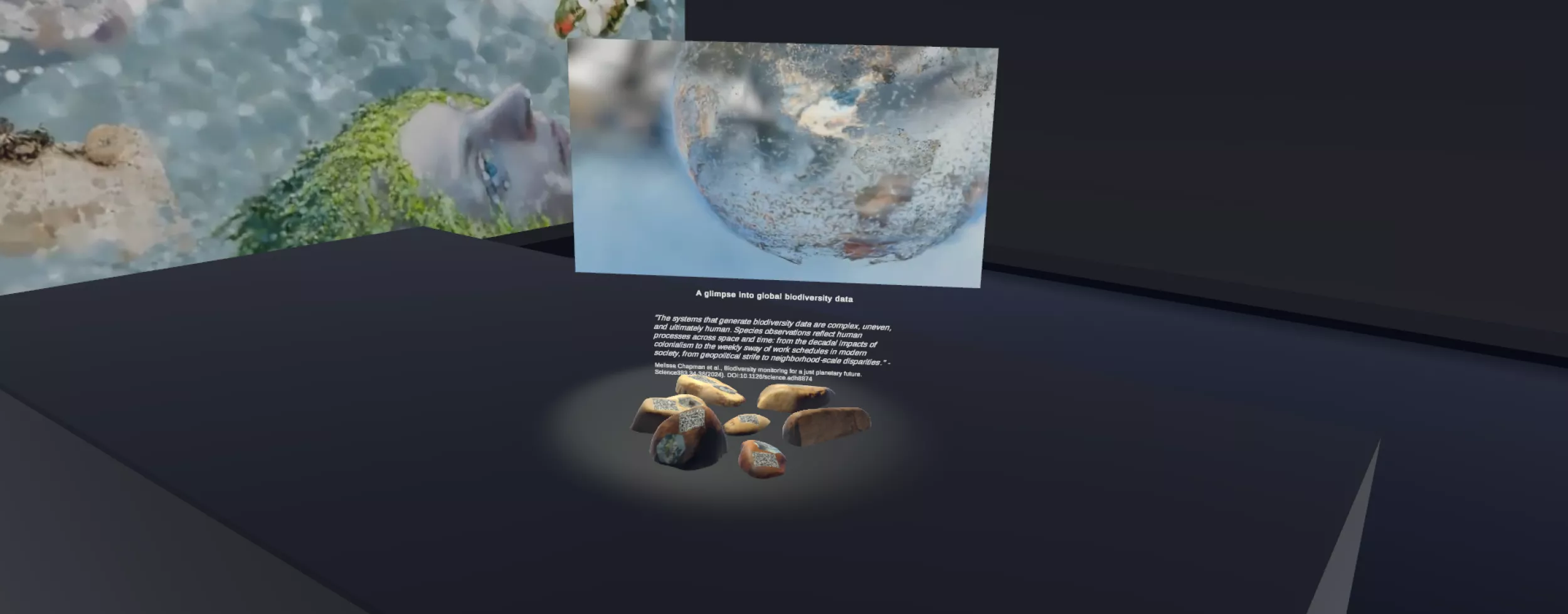 Ein digitales Ausstellungsdisplay, das ein Thema zu globalen Biodiversitätsdaten präsentiert. In der Mitte befindet sich ein schwebendes Bild einer Weltkugel mit einer verschwommenen, halbtransparenten Textur, die die biologische Vielfalt darzustellen scheint. Unter der Weltkugel steht ein Zitat, das die Komplexität und den menschlichen Einfluss auf die Daten zur biologischen Vielfalt beschreibt. Die Ausstellung befindet sich in einem dunklen, immersiven virtuellen Raum.